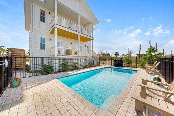 Fenced pool and back of home.