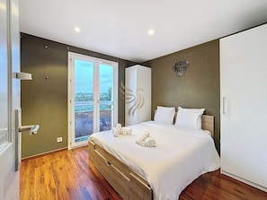 Cette chambre offre une atmosphère paisible propice à la détente. Les grandes armoires permettent un rangement spacieux, parfait pour les séjours prolongés. L'art mural ajoute une touche personnelle et accueillante.