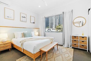 The primary bedroom is a luxurious retreat, complete with a plush queen bed, soft furnishings, and calming decor for ultimate relaxation.

