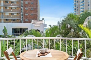 Relax on the private balcony, offering tranquil views of lush greenery and glimpses of the ocean – a perfect spot for morning coffee or evening drinks.
