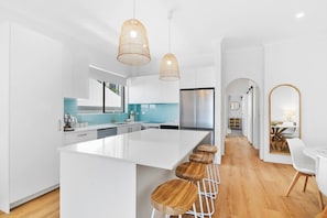 Cook up a feast in the fully equipped kitchen, boasting contemporary appliances, a stylish island bench, and ample storage space.