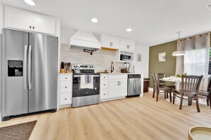 sleek, modern kitchen with a spacious two-door fridge, stainless steel appliances, and plenty of counter space—perfect for cooking and dining with ease.