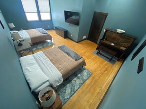 Bedroom with two queen beds, tv and desk.