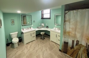 One of four bathrooms with double sinks, sit-down vanity and waterfall shower.