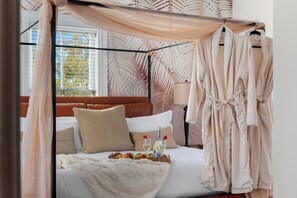 The elegant four-poster bed in Bedroom 3 is draped with flowing canopy fabric for a serene ambiance.