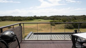 Large deck with BBQ and outdoor table and chairs.