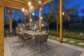 Custom pergola with a gas grill, pizza oven and Sonos—perfect for outdoor dining