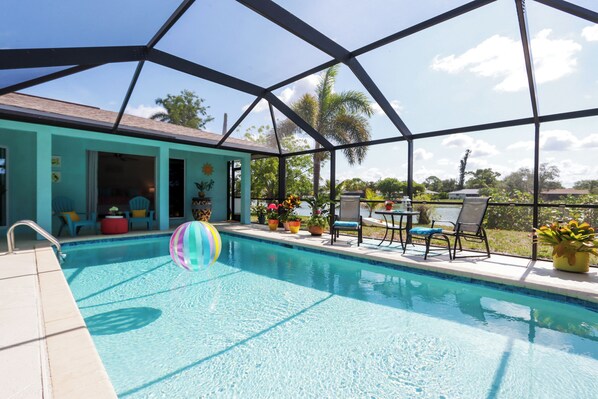 Take in views of the lake, palm trees, and direct access to both bedroom suites—a true vacation home escape.