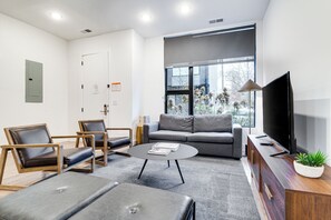 Cozy living room, with TV and a large window.