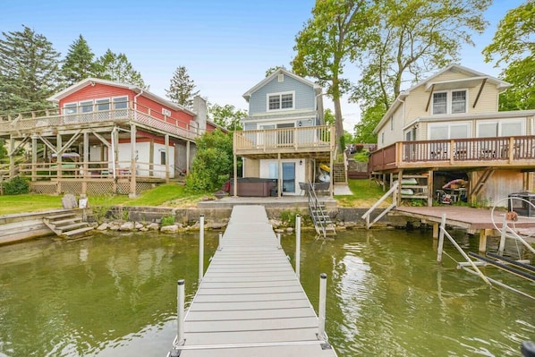 Trex decking, sun-bleached and smooth underfoot, create a rustic yet welcoming path leading to the water’s edge. The gentle lapping of the lake against the posts below provides a peaceful soundtrack, while the occasional splash of a fish or ripple fr
