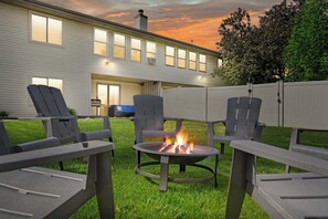 8 chair wood fire pit, fenced in backyard, yard games, charcoal grill, and lounge furniture