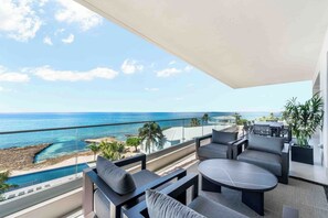 Sprawling ocean balcony with elevated beachfront views and outdoor furniture. 