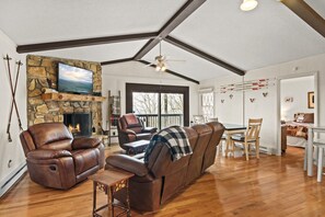 Enjoy the cozy ambiance of the living area, complete with a fireplace and picturesque views of nature.