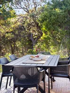 A dining table with 6 seats located in the terrace.