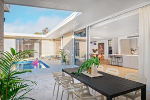 Beautiful covered pool overlooking outside dining area with BBQ