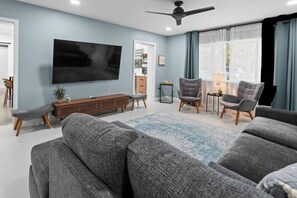 Elegant main living room with stylish decor,  seating for 12 +, large 65" flat screen TV for streaming, a cozy atmosphere - perfect for relaxing