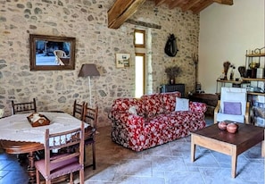 Cosy living room with stone walls and wooden cathedral ceiling