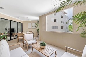 Unwind in the cosy lounge area on the balcony, surrounded by tropical greenery and natural light.
