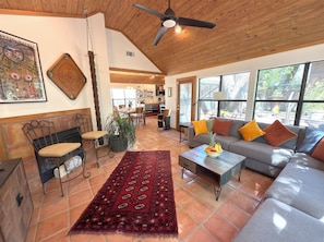 Vaulted living room, door to deck, sofa, coffee table, Smart TV ceiling fan