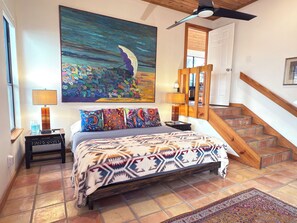 King bed and master suite, night tables, and ceiling fan, steps to living room