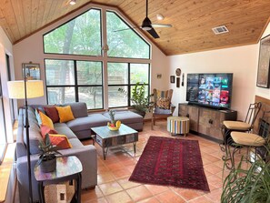 Vaulted living room, door to deck, sofa, coffee table, Smart TV ceiling fan
