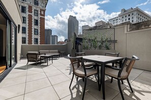 Spacious rooftop terrace, featuring modern outdoor seating and city skyline views.