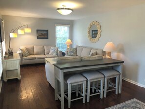 A large sofa table with stool seating compliments the large living room.