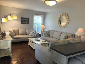 The living room has been decorated in cool coastal tones with custom lighting.