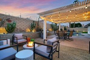 A look at our fire pit, outdoor dining area with string lights, and heated pool / hot tub.