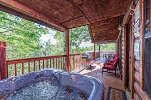 Spacious deck with a private hot tub, BBQ grill, and cozy seating, perfect for relaxing and enjoying serene mountain views. #summer