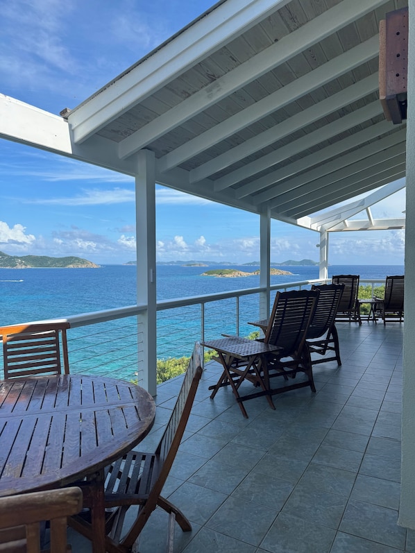 Outdoor dining table and reclining Balinese deck chairs with incredible views.  