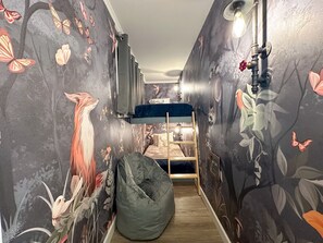 The third sleeping area is a cozy forest cave with two twin bunks for children, it closes with a barn door, is lit with custom industrial lighting, and offers ample outlets for tablets and portable electronics.