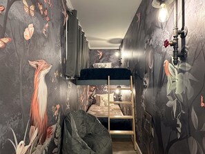 The third sleeping area is a cozy forest cave with two twin bunks for children, it closes with a barn door, is lit with custom industrial lighting, and offers ample outlets for tablets and personal electronics.