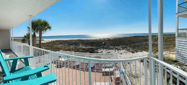 Large balcony overlooking pool area with unobstructed views of the white sand beach and waves.