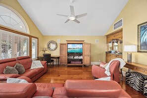 Living room features a TV, wooden accents, and plush seating for a cozy vibe.