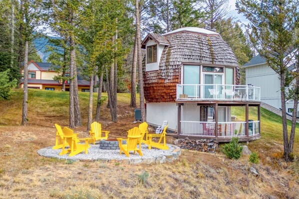 Backyard of Hilltop Dome with two patio/balcony spaces, a BBQ, outdoor seating & a dedicated fire pit area with epic lake & mountain views.