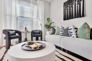 Revel in the warmth and beauty of our living room, thoughtfully styled with gorgeous furniture and soft, colorful pillows!