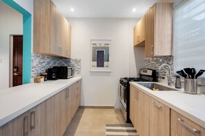 A bright and roomy kitchen with elegant countertops and plenty of storage space.