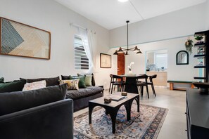 A tastefully designed living area with a wooden dining table and abundant natural light.