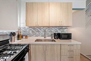 Cook with ease in this modern kitchen featuring sleek appliances, ample counter space, and stylish finishes.