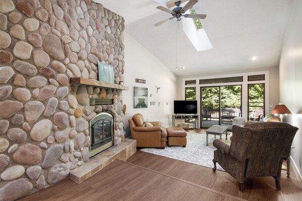 Main living area with electric fireplace, TV, back porch.