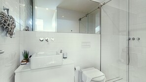 Spotless modern bathroom with a walk-in shower and sleek finishes. Fresh towels and essentials provided. #Bathroom #Amenities