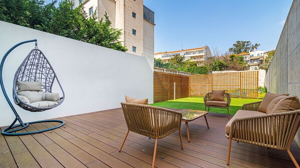 Private outdoor oasis with seating, a swing chair, and green space. Perfect for relaxing or enjoying sunny days in style. #Patio #Outdoors