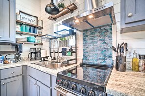 Stylish and fully stocked kitchen with modern appliances and a beautiful backsplash—everything you need for cooking up a delicious meal.