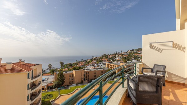 Calandiva Apartment by LovelyStay: Relax on the balcony with cozy outdoor seating, enjoying stunning ocean views, overlooking the pool and street. A serene escape with 2 bedrooms and private parking. #balcony #oceanview