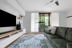 The inviting living area includes a large sofa and TV, where you can settle in with a movie after a day of work or sightseeing.