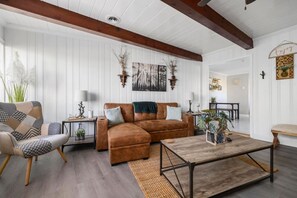 The cozy living room is decorated with a modern rustic and boho theme.
