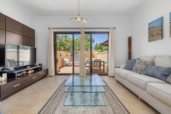 Welcome to your cheerful oasis! This bright living space opens up to a sunny outdoor space, perfect for fun gatherings and cozy relaxation!