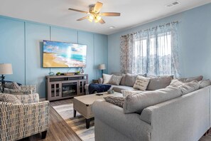 Bright living area with sofa sleeper, Smart TV, and electric fireplace 