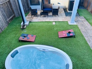 Private fenced backyard with hot tub, patio and corn hole